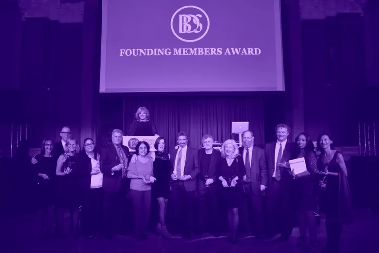 A lof of people on a podium at an award gala.
