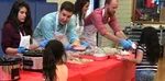 Volunteers handing out food to some kids.