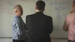 White guys standing in front of a whiteboard.