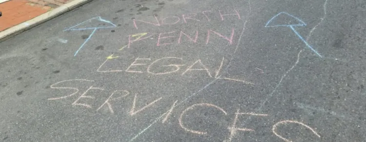 North Penn Legal Services written in chalk on asphalt.